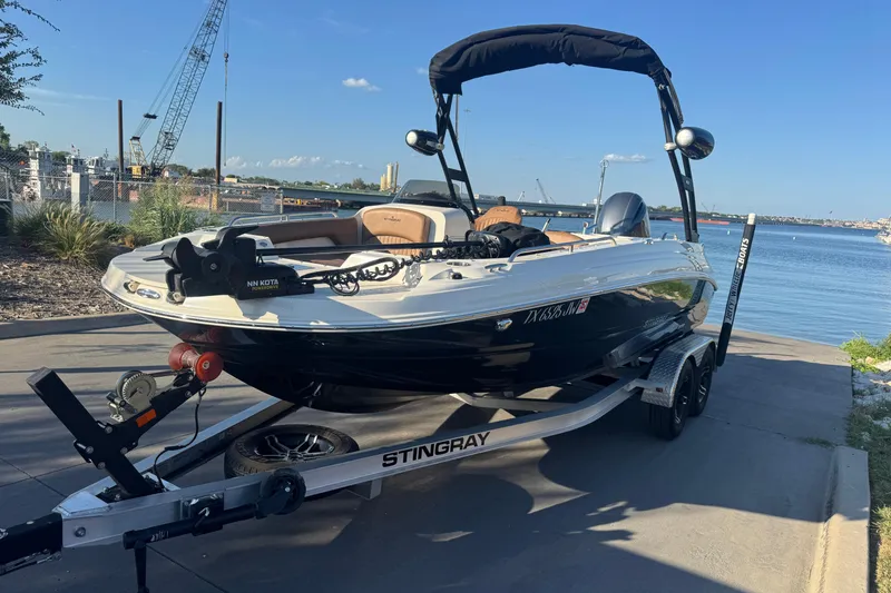 Slide: The Image of 2021 Stingray 192 SC boat on trailer by waterfront, sunny day. - 8