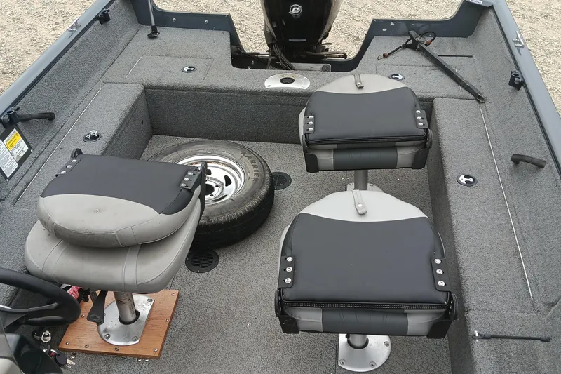 Slide: The Image of 2019 Tracker Pro Guide V-16 SC boat interior with two seats and spare tire. - 13