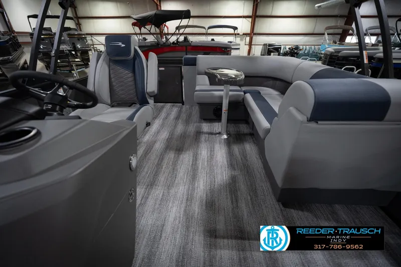 Slide: The Image of 2026 Bennington 23 SLJ pontoon boat interior with gray and blue seating, showcased indoors. - 16