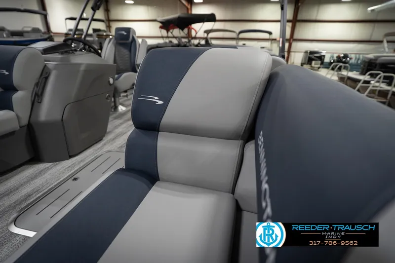 Slide: The Image of 2026 Bennington 23 SLJ boat interior with gray seating, showcased in a showroom. - 22