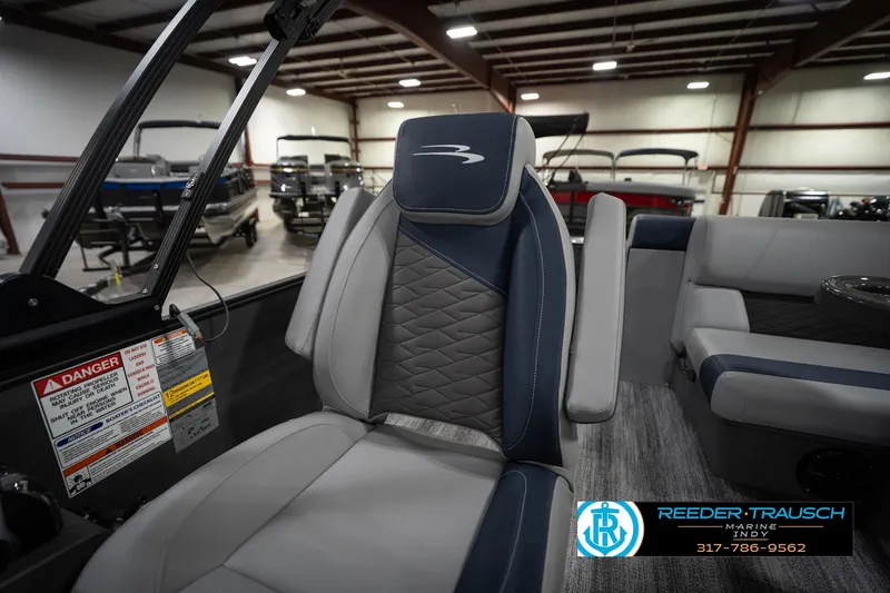 Slide: The Image of 2026 Bennington 23 SLJ boat interior with storage compartment open, displayed at Reeder-Trausch Marine. - 24