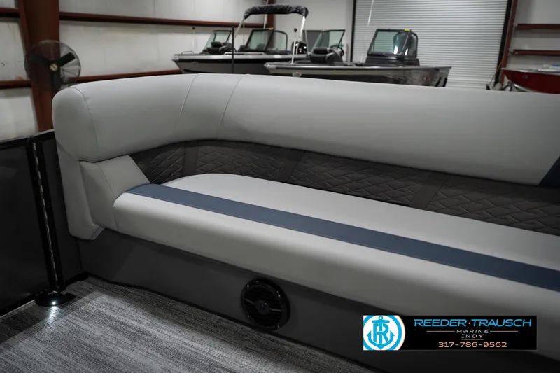Slide: The Image of 2026 Bennington 23 SLJ boat interior with gray and blue seating, Reeder-Trausch Marine logo. - 46