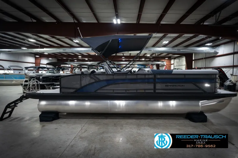 Slide: The Image of 2026 Bennington 23 SLJ pontoon boat in showroom, featuring sleek design and canopy. - 6