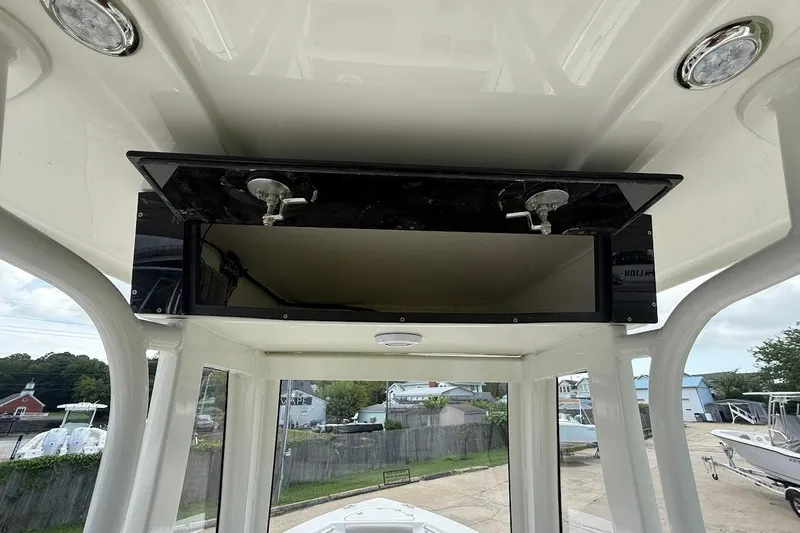 Slide: The Image of 2026 Key West 219 FS boat console with open storage compartment and overhead lighting. - 15