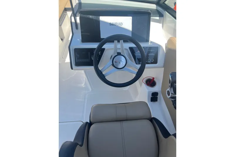 Slide: The Image of 2024 Sea Ray SPX 230 boat cockpit with steering wheel and dashboard controls. - 11
