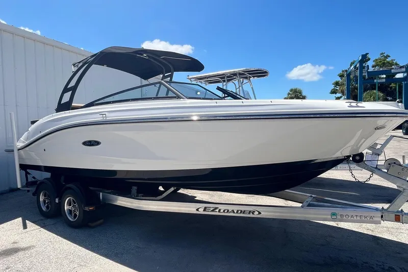 Slide: The Image of 2024 Sea Ray SPX 230 boat on trailer, sleek design, white exterior, sunny day. - 2