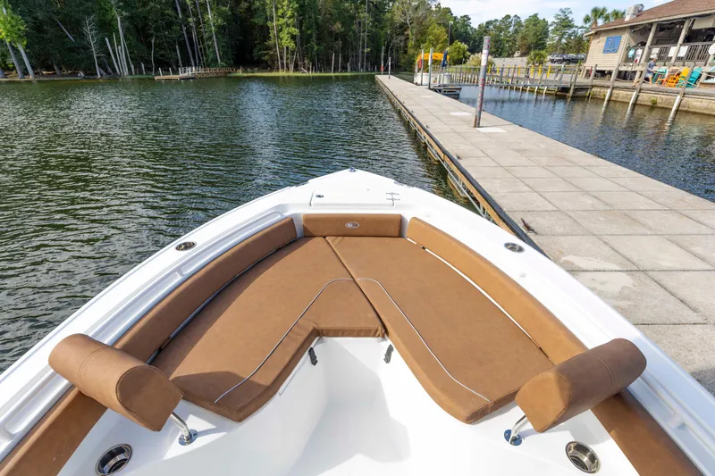 Slide: The Image of 2026 Sea Hunt Ultra 235 SE boat docked by a serene lakeside pier. - 10