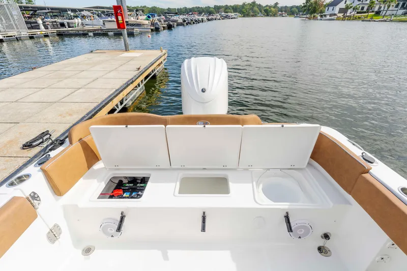 Slide: The Image of 2026 Sea Hunt Ultra 235 SE boat interior with open storage compartments at dock. - 3