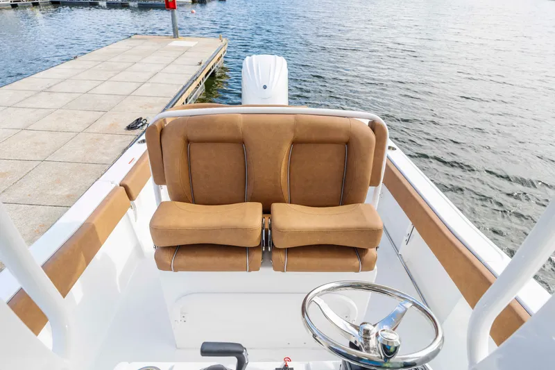 Slide: The Image of 2026 Sea Hunt Ultra 235 SE boat interior with tan seating and steering wheel. - 5