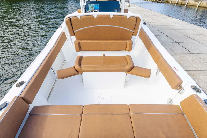Slide: The Image of 2026 Sea Hunt Ultra 235 SE boat interior with tan seating, dockside view. - 8