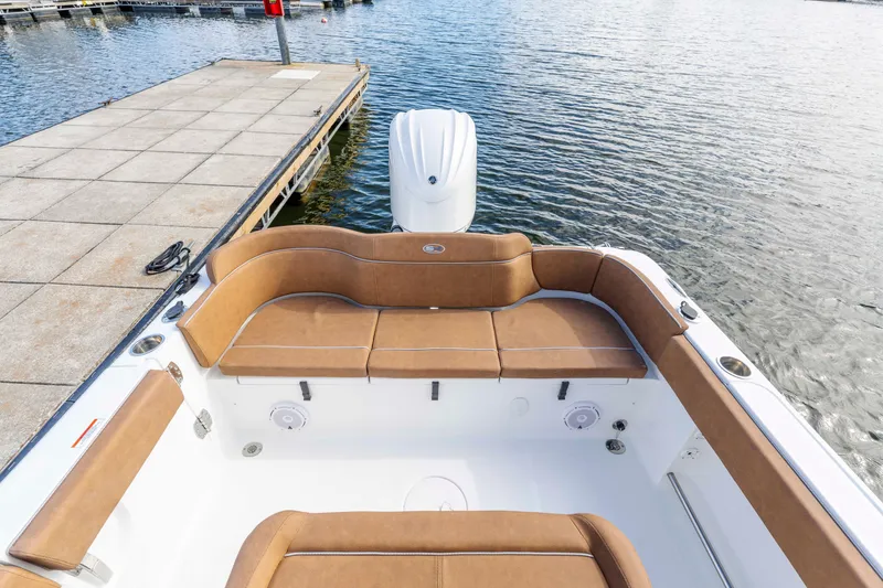 Slide: The Image of 2026 Sea Hunt Ultra 235 SE boat interior with tan seating at dock. - 9