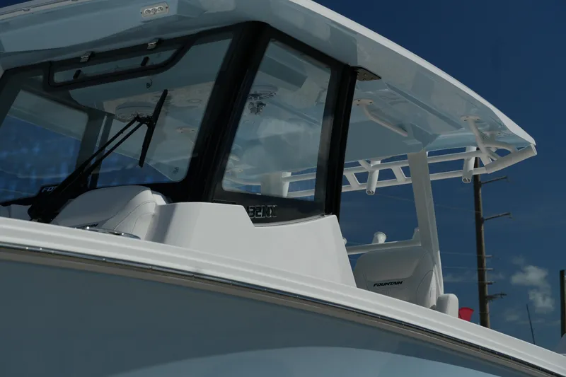 Slide: The Image of 2025 Fountain 32 NX boat, sleek design, white exterior, modern windshield, blue sky background. - 12