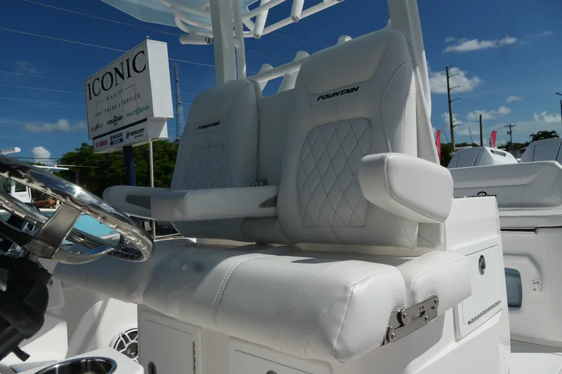 Slide: The Image of 2025 Fountain 32 NX boat with luxurious white seating and steering wheel, at Iconic Marine. - 14