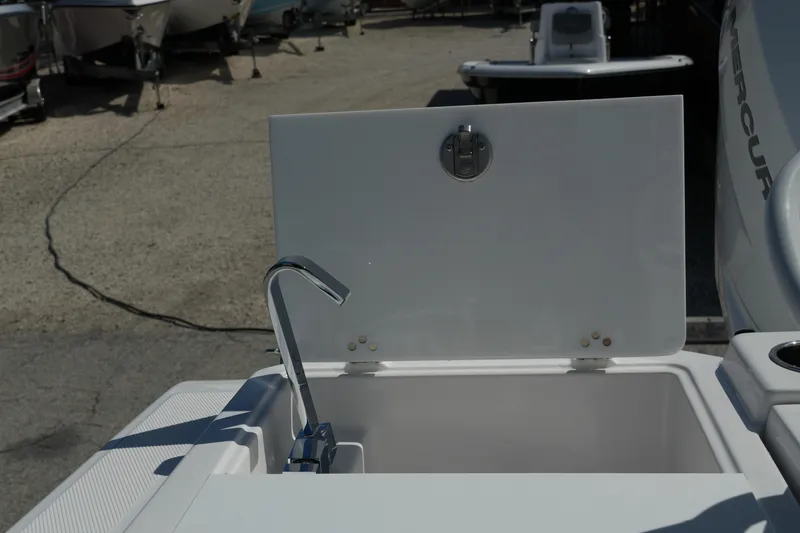 Slide: The Image of Open storage compartment on a 2025 Fountain 32 NX boat, featuring a sleek faucet design. - 18