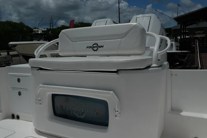 Slide: The Image of 2025 Fountain 32 NX boat interior with white seating and storage compartment. - 19