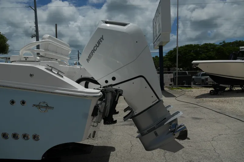 Slide: The Image of 2025 Fountain 32 NX boat with Mercury outboard motor, parked outdoors under cloudy sky. - 24