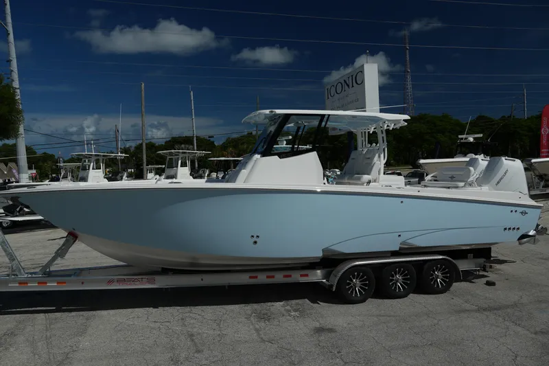 Slide: The Image of 2025 Fountain 32 NX boat on trailer, displayed outdoors under clear sky. - 6