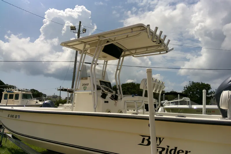 Slide: The Image of 2015 KenCraft 2060 BAYRIDER boat with T-top, parked outdoors under a cloudy sky. - 25