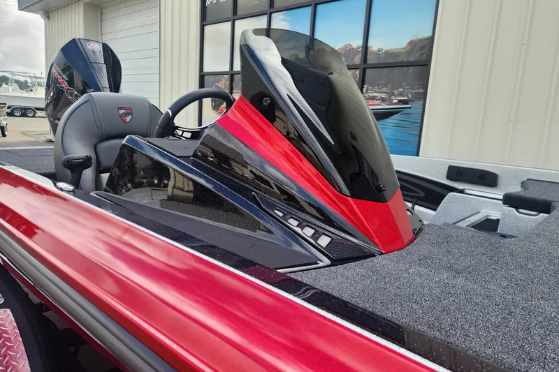 Slide: The Image of 2025 Triton 20XP Patriot boat with sleek red and black design, parked outdoors. - 10