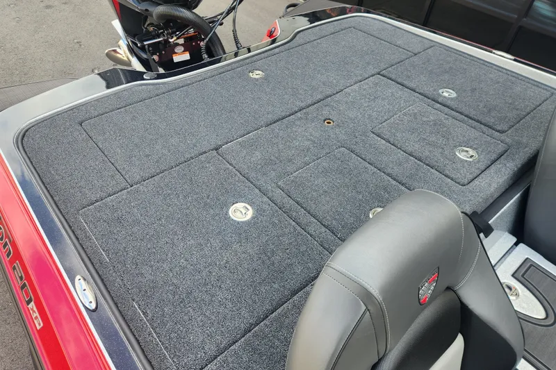 Slide: The Image of 2025 Triton 20XP Patriot boat deck with gray carpet and storage compartments. - 13