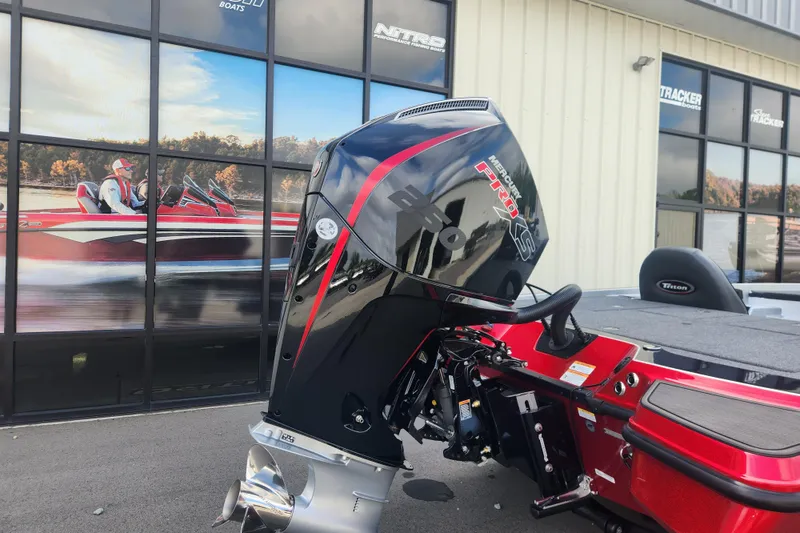 Slide: The Image of 2025 Triton 20XP Patriot boat with Mercury Pro XS engine, parked outside showroom. - 4