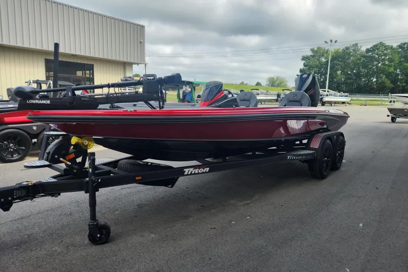 Slide: The Image of 2025 Triton 20XP Patriot boat on trailer, parked outdoors, featuring sleek red design. - 5