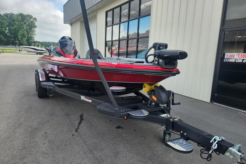 Slide: The Image of 2025 Triton 20XP Patriot boat in red, parked outside a showroom. - 6