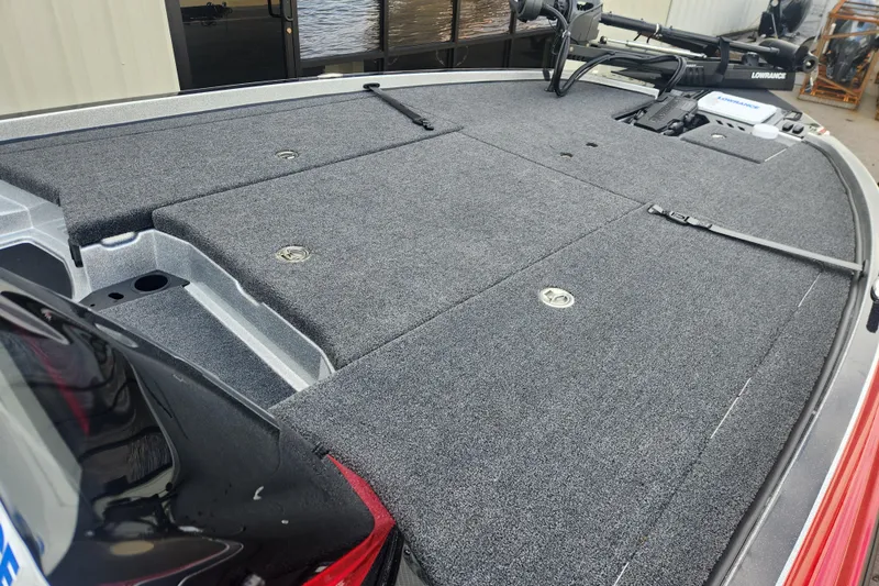 Slide: The Image of 2025 Triton 20XP Patriot boat deck with carpeted surface and storage compartments. - 9