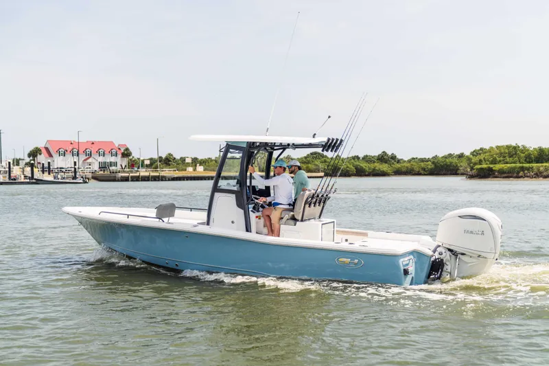 Slide: The Image of 2026 Sea Hunt BX 25 FS boat cruising on a calm waterway near a marina. - 11