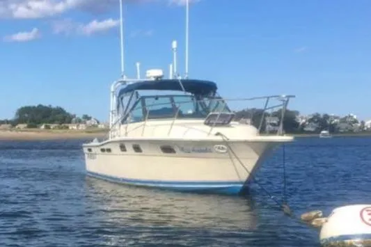 Slide: The Image of 1984 Tiara 2700 boat anchored on calm water under a clear blue sky. - 3