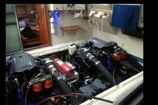 Slide: The Image of Engine room of a 1984 Tiara 2700 boat, featuring dual engines and fire extinguisher. - 6