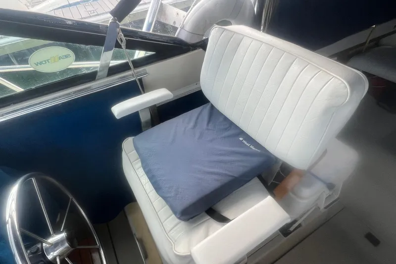 Slide: The Image of Captain's chair in a 1984 Tiara 2700 boat with a blue cushion and steering wheel. - 8