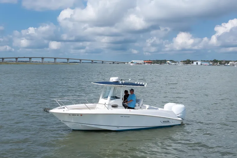 Slide: The Image of 2010 Boston Whaler 250 Outrage boat on calm water under cloudy sky. - 21