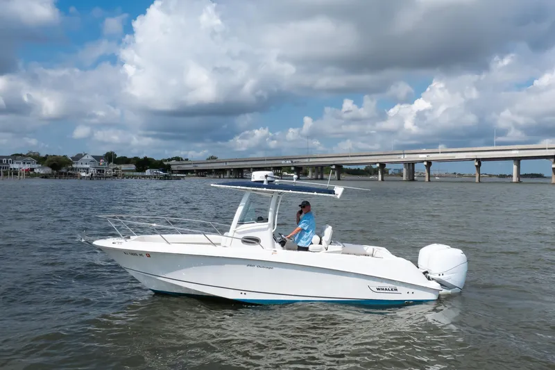 Slide: The Image of 2010 Boston Whaler 250 Outrage speeding on open water, showcasing sleek design and performance. - 4