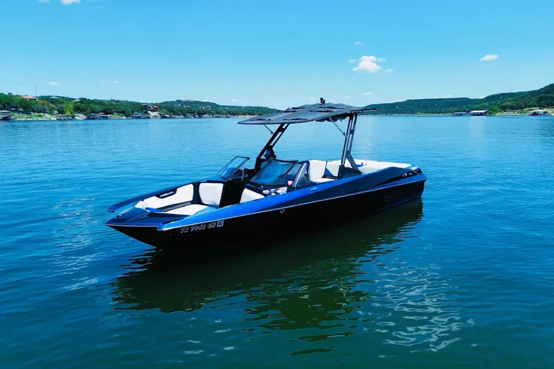 The Image of 2014 Axis A24 boat on a serene lake under a clear blue sky. - 0