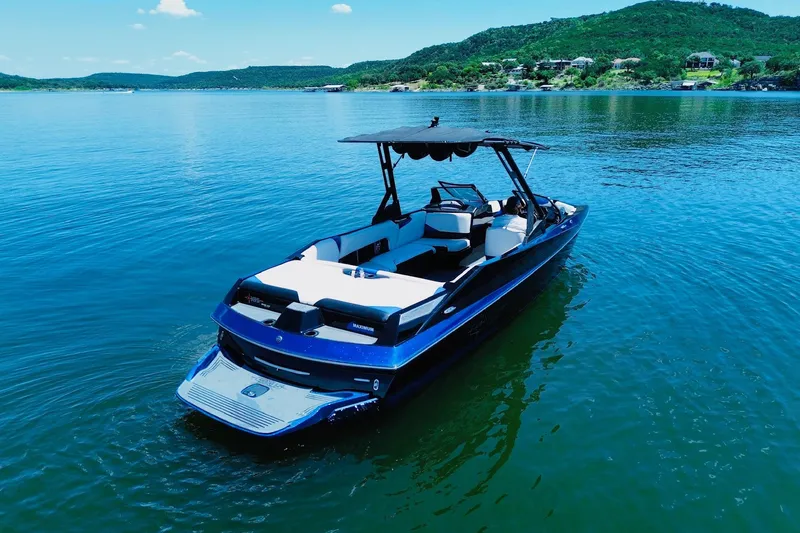 Slide: The Image of 2014 Axis A24 boat on a serene lake with scenic hills in the background. - 1