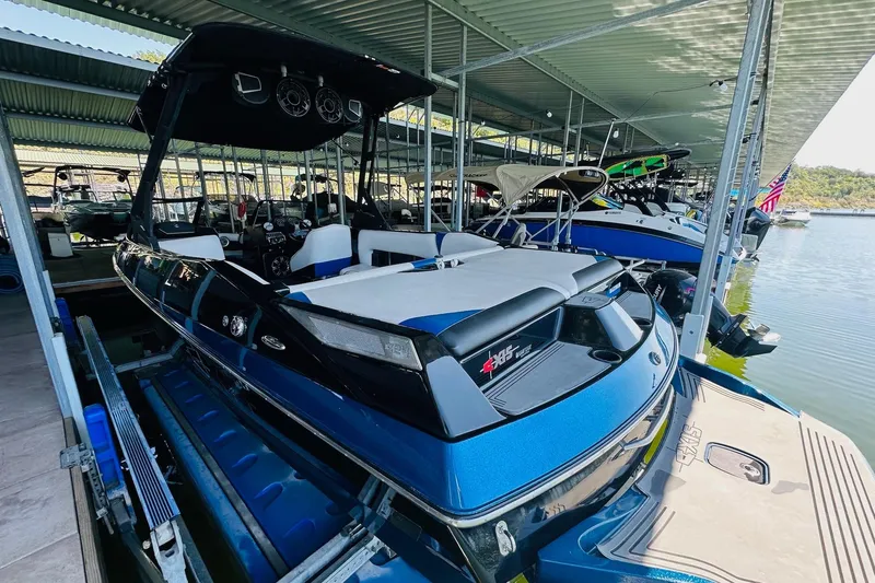 Slide: The Image of 2014 Axis A24 boat docked in a marina, featuring a sleek blue design. - 12