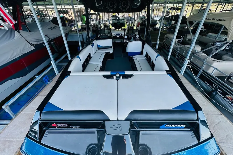 Slide: The Image of 2014 Axis A24 boat interior with spacious seating and modern design in a marina. - 13