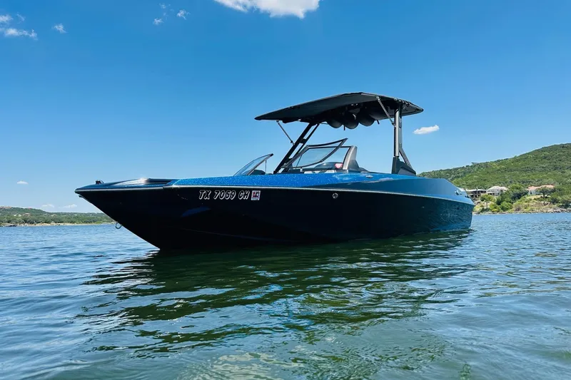 Slide: The Image of 2014 Axis A24 boat on a lake under clear blue sky. - 2