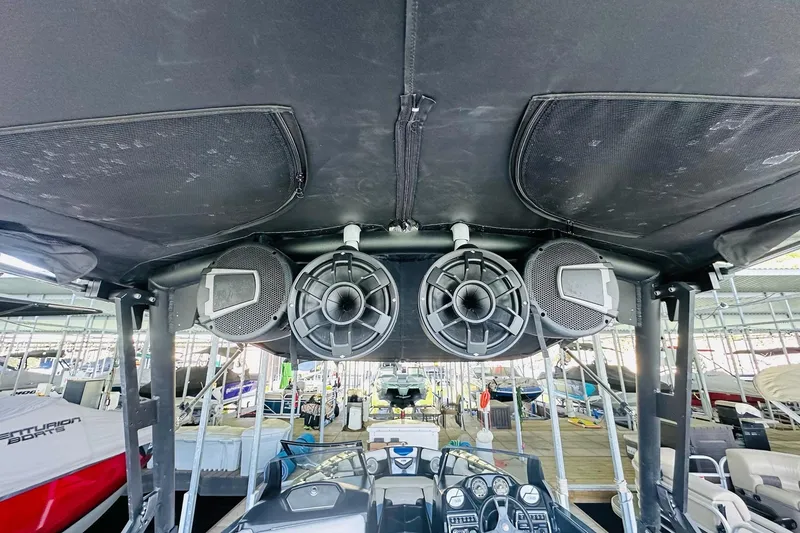 Slide: The Image of 2014 Axis A24 boat with mounted speakers under canopy at marina. - 20