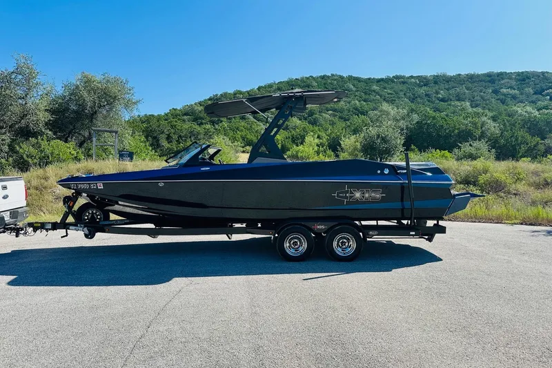 Slide: The Image of 2014 Axis A24 boat on trailer, parked in scenic outdoor setting. - 9