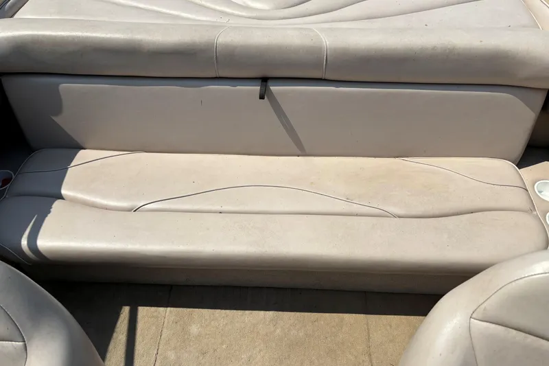 Slide: The Image of 2001 Crownline 18' boat interior seating with light beige upholstery. - 13