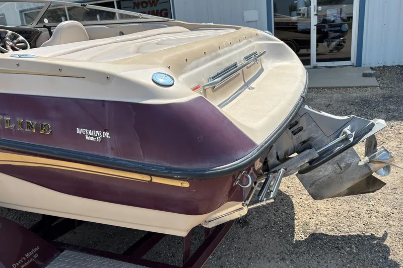 Slide: The Image of 2001 Crownline 18' boat with outboard motor, parked outside a building. - 3