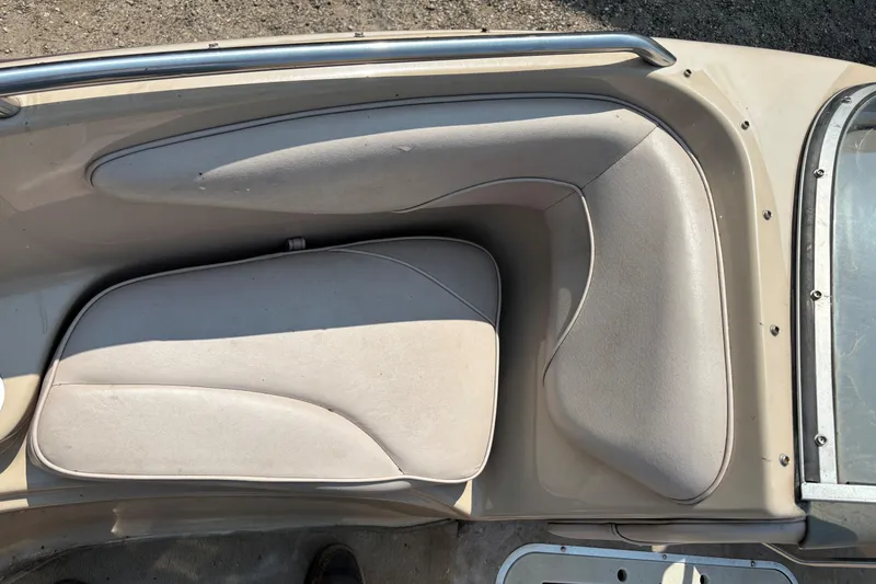 Slide: The Image of Crownline 18' 2001 boat interior seating with beige upholstery and metal railing. - 11