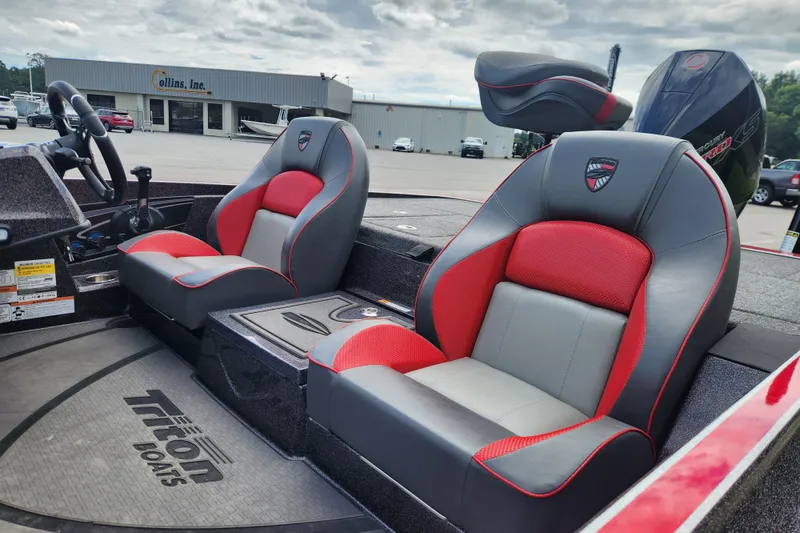 Slide: The Image of 2025 Triton 21XP Patriot boat interior with red and gray seats, steering wheel, and motor. - 11