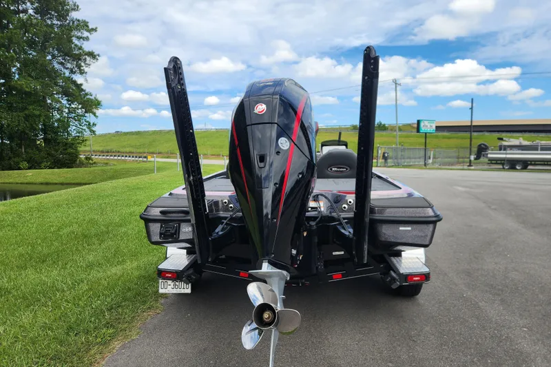 Slide: The Image of 2025 Triton 21XP Patriot boat with powerful outboard motor on a sunny day. - 3