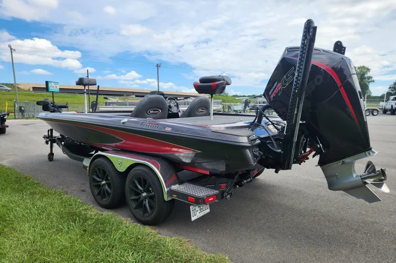 Slide: The Image of 2025 Triton 21XP Patriot boat with powerful engine, parked on a trailer under a blue sky. - 4