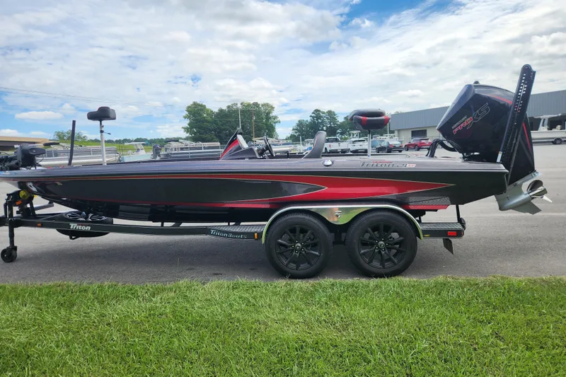Slide: The Image of 2025 Triton 21XP Patriot boat on trailer, parked outdoors under cloudy sky. - 5
