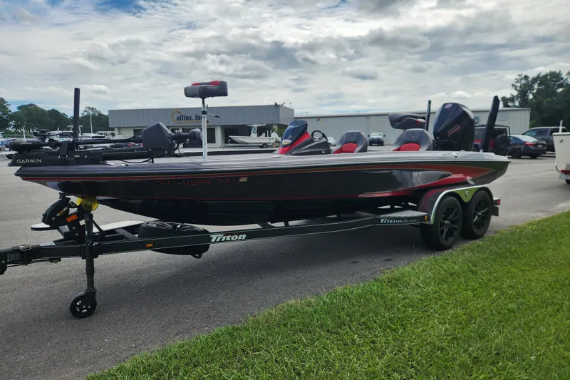 Slide: The Image of 2025 Triton 21XP Patriot boat on trailer, parked outdoors under cloudy sky. - 6