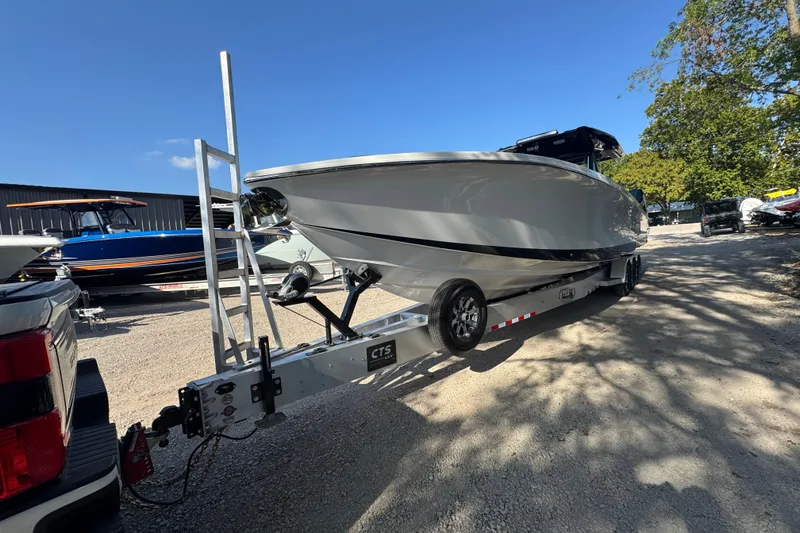 Slide: The Image of 2024 Nor-Tech 400 Supersport boat on trailer, parked outdoors near modern buildings. - 7